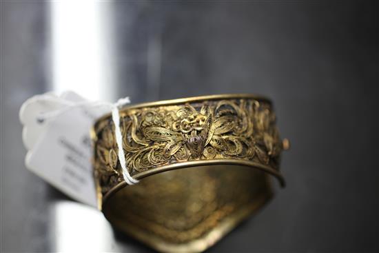 A Chinese silver gilt filigree bracelet inset with three carved jadeite oval foliate panels.